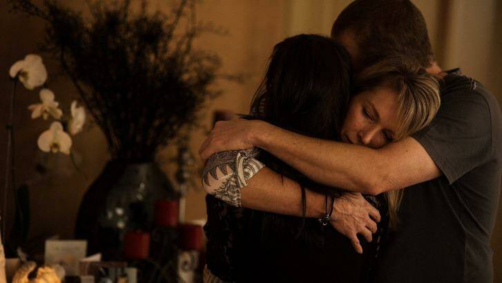 Aaron Short's parents and girlfriend embrace in mourning in front of a shrine in their family home. Photo: Josh Robenstone