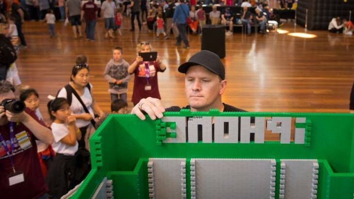 Building a future: Lego fanatic Tim Burdon creates a phone booth at Brickvention, at the Royal Exhibition Building. Photo: Simon Schluter