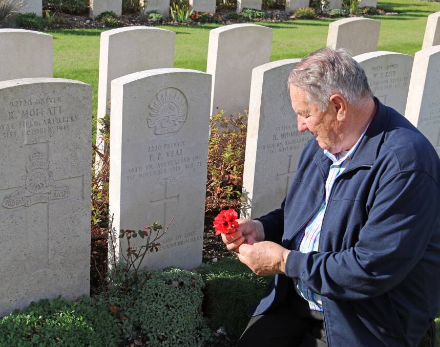 REMEMBRANCE: Ray Veal pays his respects at his uncle's grave during his visit to the St Sever Cemetery in Rouen, France. Picture: Supplied