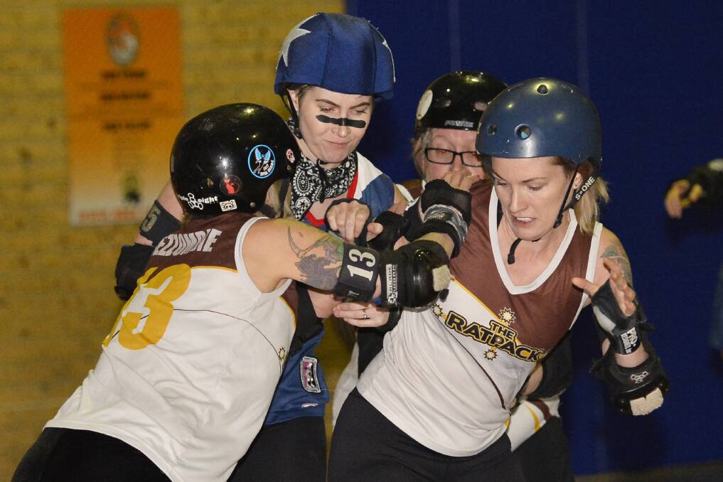 TOUGH BATTLE: The Rat Pack's Berry Wooding and Meredith Ramsay try to block Nikita Rigby of the South Sea Roller Derby Sirens. Pictures: Dylan Burns