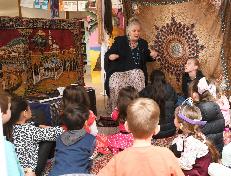 ENTHRALLED: Storyteller Anne E Stewart captivates her audience with tales from long ago and faraway during the Baha'i community's Children's Festival on Saturday in Delacombe. Picture: Lachlan Bence 