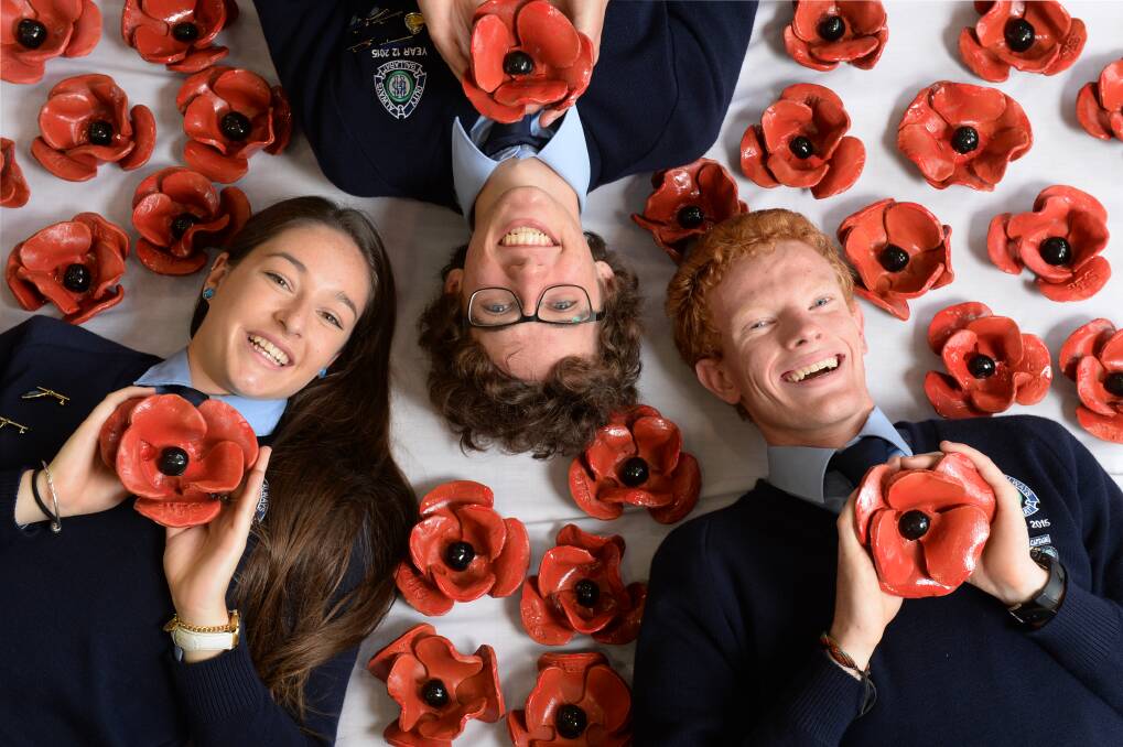 POPPY FIELD: Ballarat High students Samantha Treadwell, Stuart Brown and Liam McQualter with some of the 1022 ceramic poppies students have made for the Anzac centenary. Proceeds from their sale will go to Legacy. PICTURE: KATE HEALY