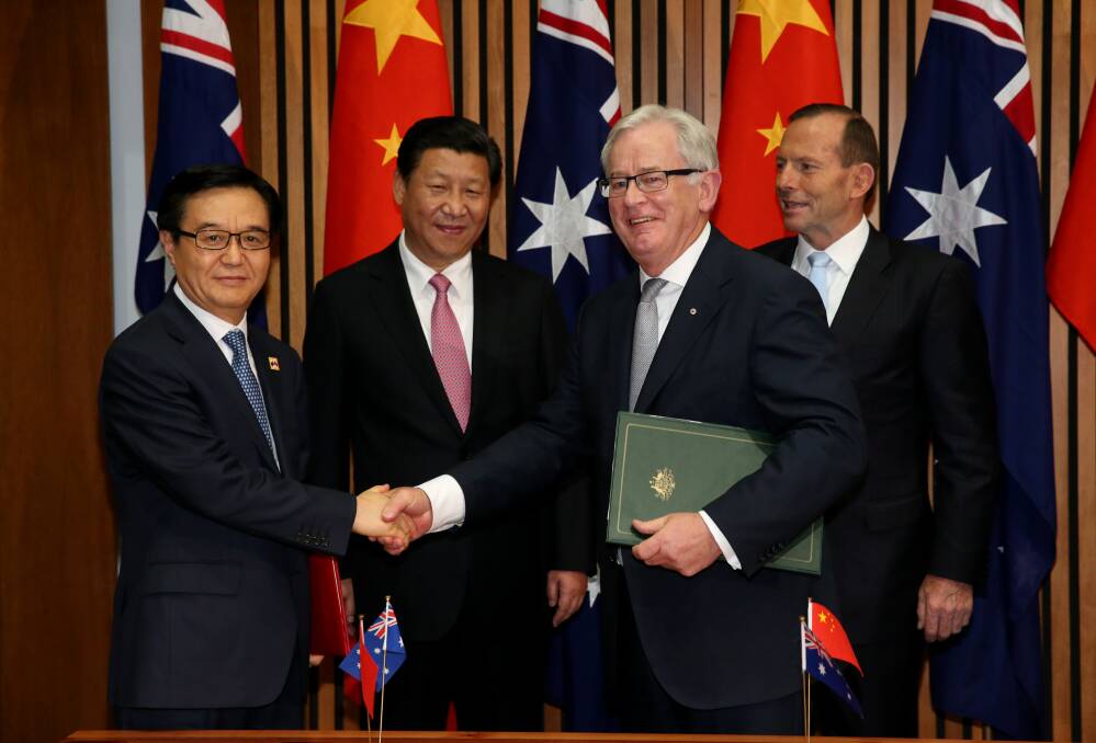 Chinese President Xi Jinping and PM Tony Abbott watch as Trade Minister Andrew Robb and Chinese Commerce Minister Gao Hucheng sign a Declaration of Intent on the FTA agreement with China.