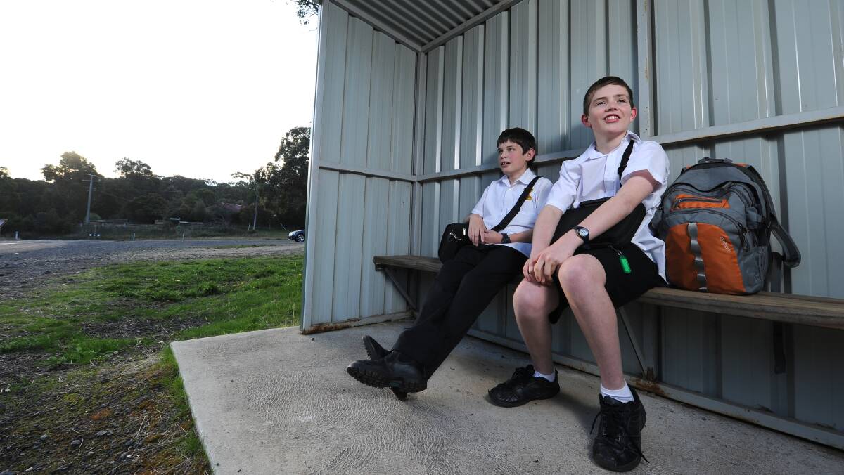 Year 7 boys Patrick Boyd and Leo Bourke wait for their bus in this file photo..