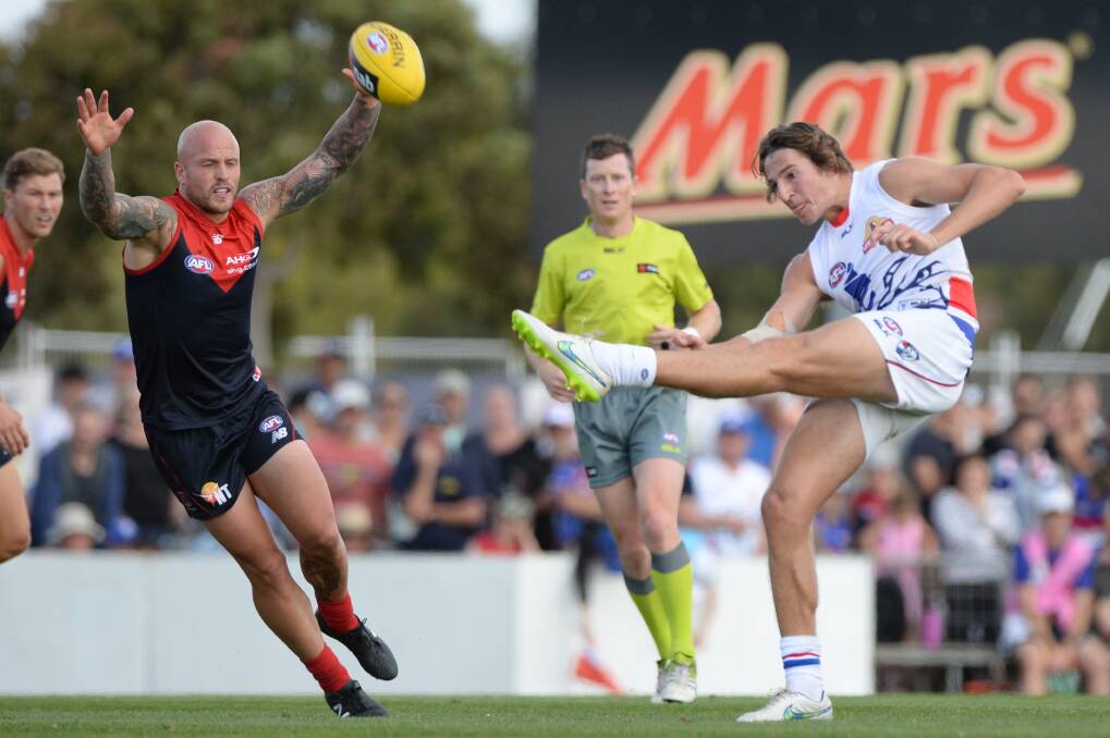 Out of reach: Melbourne captain Nathan Jones attempts to smother a kick by Western Bulldogs rising star Marcus Bontempelli at Eureka Stadium on Saturday. PICTURE: Kate Healy