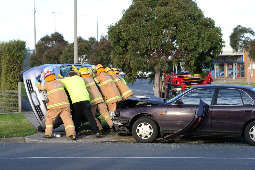 Wrong way up: Emergency crews turn over a flipped car after the collision at the intersection of Rubicon Street, Talbot Street South and Clarkson Street. PICTURE: KATE HEALY