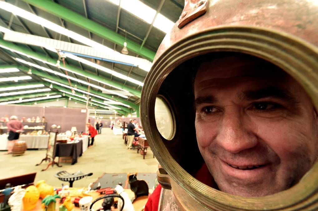 Taking the plunge: Antique dealer Craig Oliver with his 1950s deep-sea diving helmet at the Ballarat Spring Antique Fair.  
PICTURE: JEREMY BANNISTER
