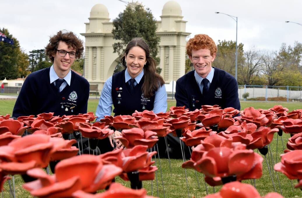 INSPIRING: Ballarat High School students Stuart Brown, Samantha Treadwell and Liam McQualter among the poppy field representing former students who have fought for Australia. PICTURE: JEREMY BANNISTER