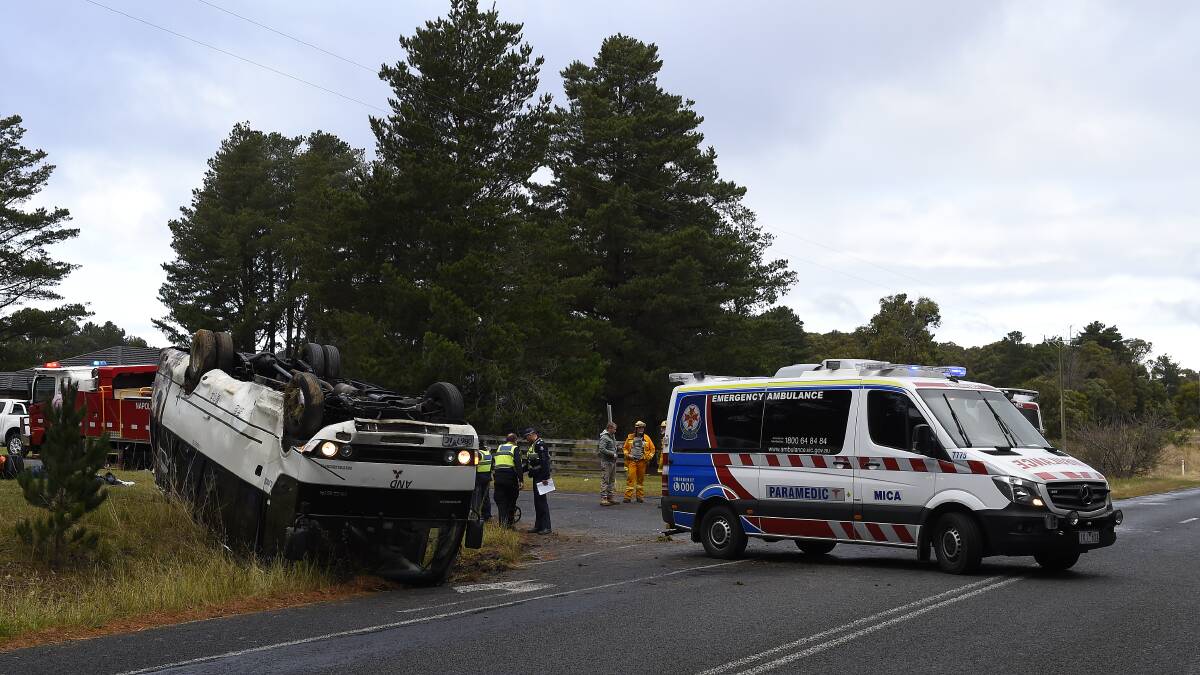 Lucky escape: Emergency services workers at the scene of the bus roll-over on the Colac-Ballarat Road at Enfield on Saturday afternoon. PICTURE: JUSTIN WHITELOCK