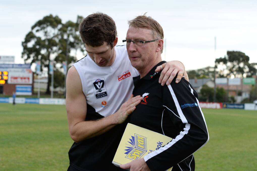 Relief: North Ballarat coach Gerard FitzGerald is embraced by captain Michael Searl after victory over Frankston. 
