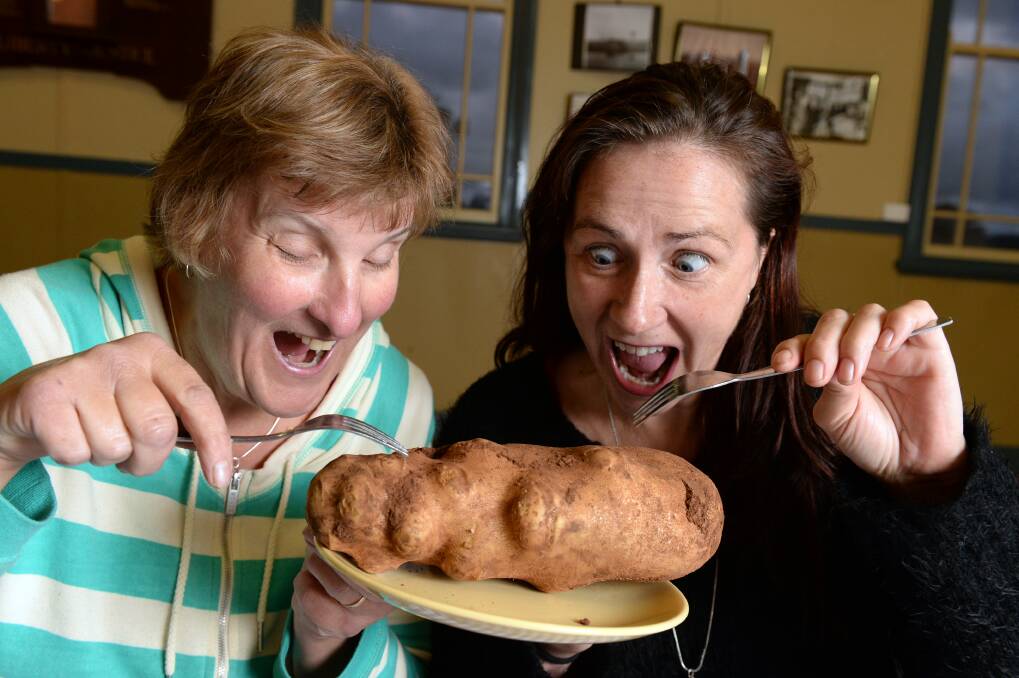 Tuck in: Spud Dinner organisers Ngaire McKay and Liz Kelly with a contender for biggest spud. PICTURE: KATE HEALY