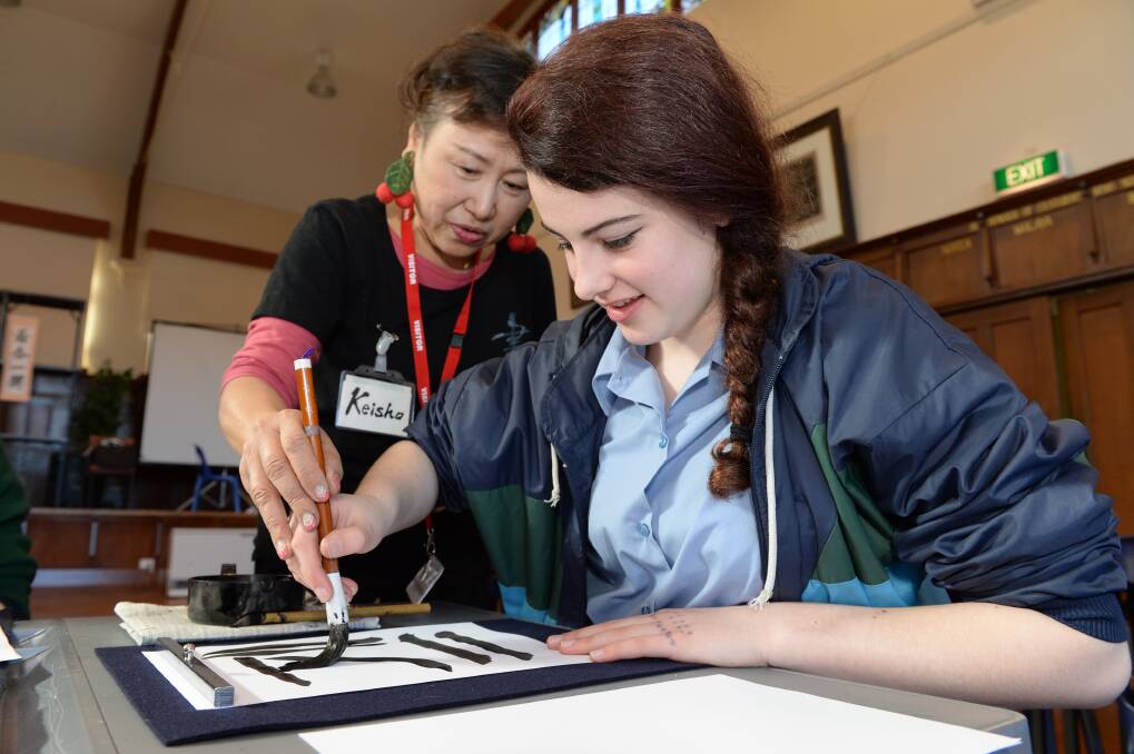 Like this: Keiko Fukumitsu and year 10 student Amber Moyes-Allan practise calligraphy. PICTURE: KATE HEALY