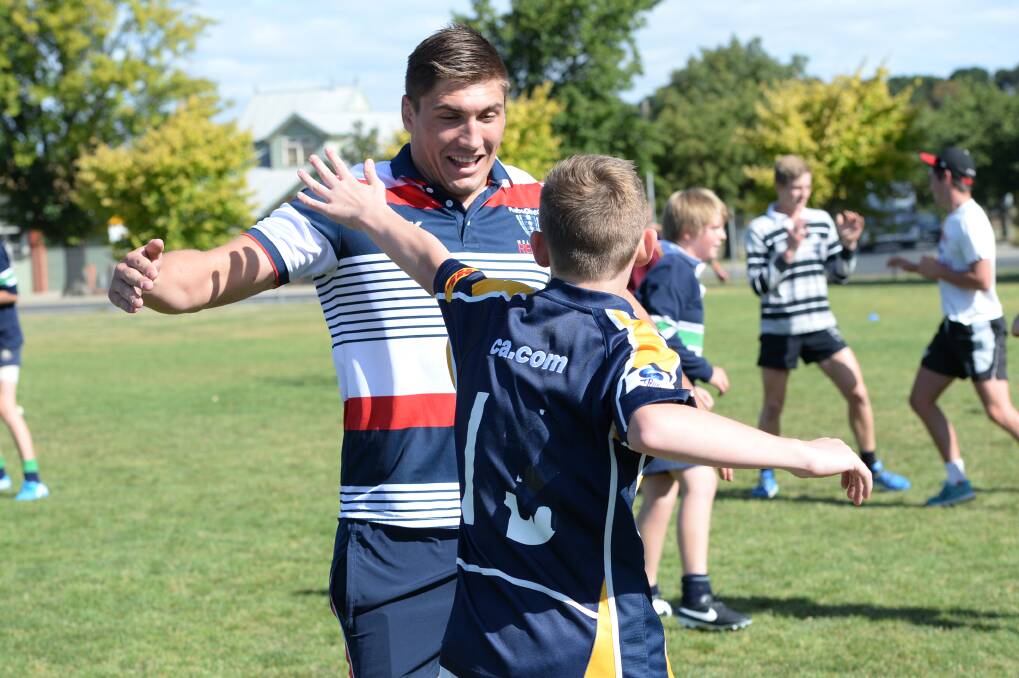 Roadshow: Sean McMahon shows Joel Dempsey, 12, some moves during the Melbourne Rebels rugby union clinic at St Patrick’s College. PICTURE: KATE HEALY