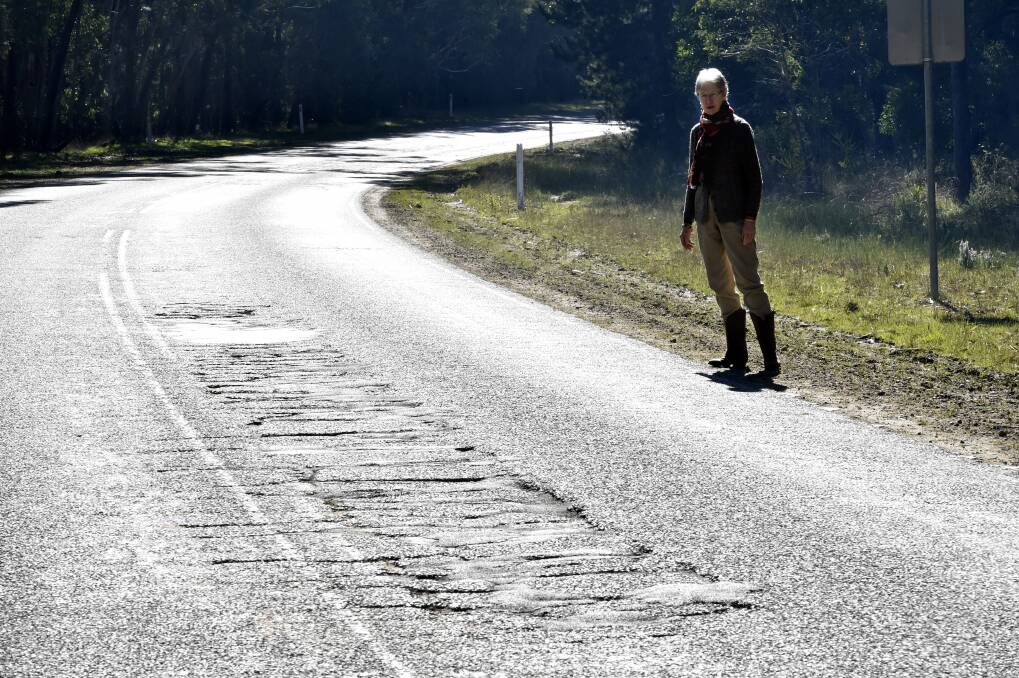 Not happy: Enfield resident Kim Kucera beside the badly damaged Colac-Ballarat Road. PICTURE: JEREMY BANNISTER