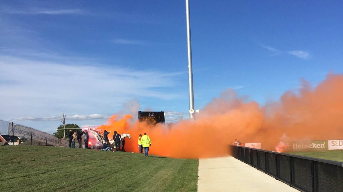 Seeing red: Flares released by Melbourne Victory fans caused a scene at Morshead Park on Saturday. 