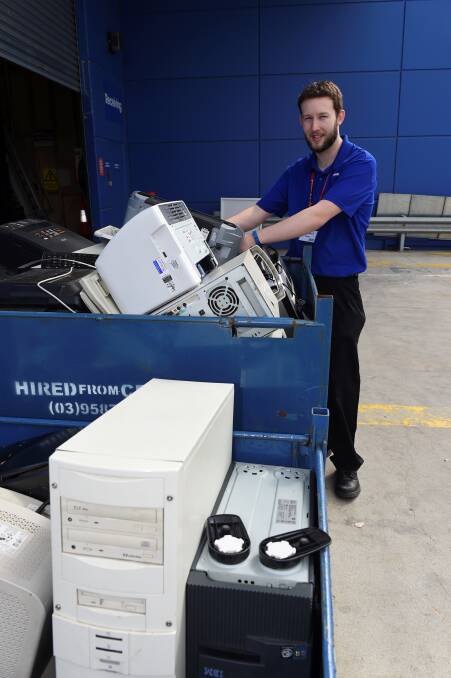 Recycled: Officeworks store manager Kael Aisbett beside a skip bin filled with old electronic parts.
PICTURE: LACHLAN BENCE