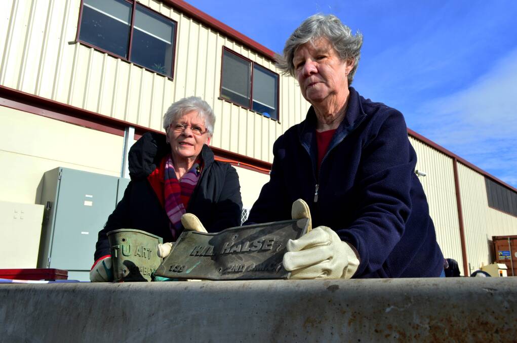 Restoration: Joan Benton and Lynette Singleton demonstrate how they straighten a bent plate. PICTURE: DYLAN BURNS