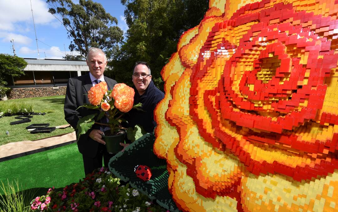 Mind-blowing: Mayor John Philips and Lego-certified professional Ryan McNaught with the giant Lego begonia. PICTURE: LACHLAN BENCE