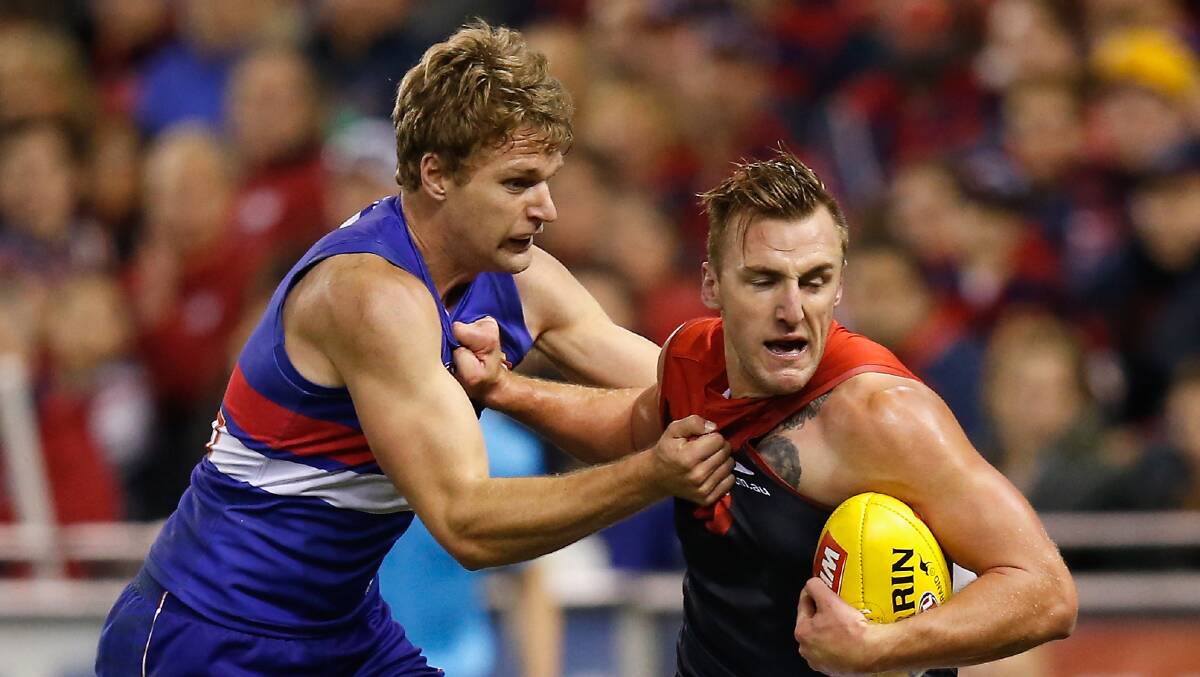 Melbourne's Lydnen Dunn tries to fend off a tackle from Western Bulldogs' Jake Stringer.