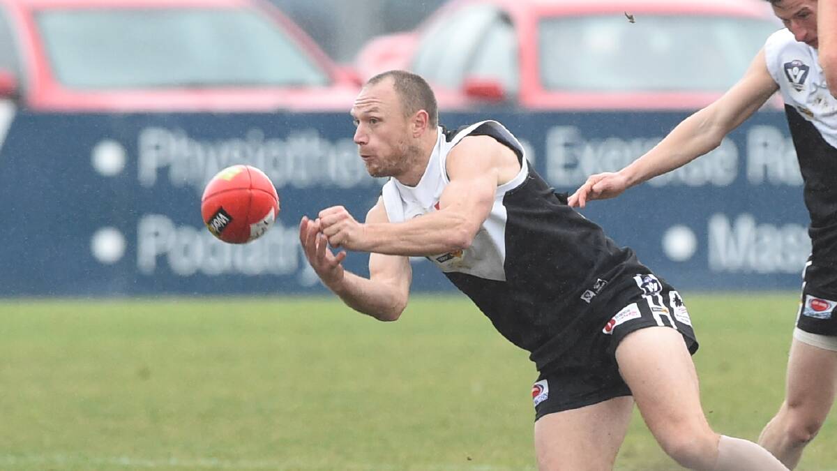 North Ballarat City captain Jason McNamara fires off a handball.