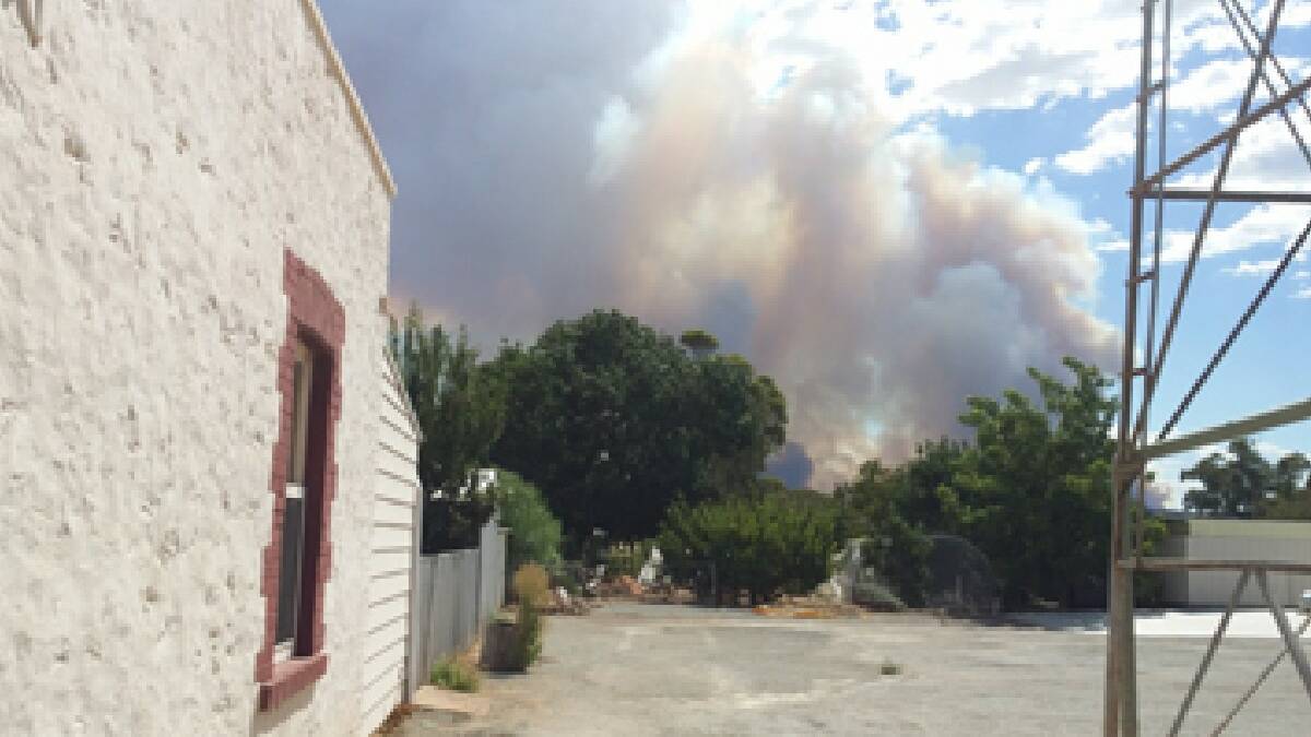 A plume of white smoke can be seen in the hills at the rear of the CFS service station in Laura. Photo by Susie Higgins, whose shop supplied food to the 
fire-fighters.
