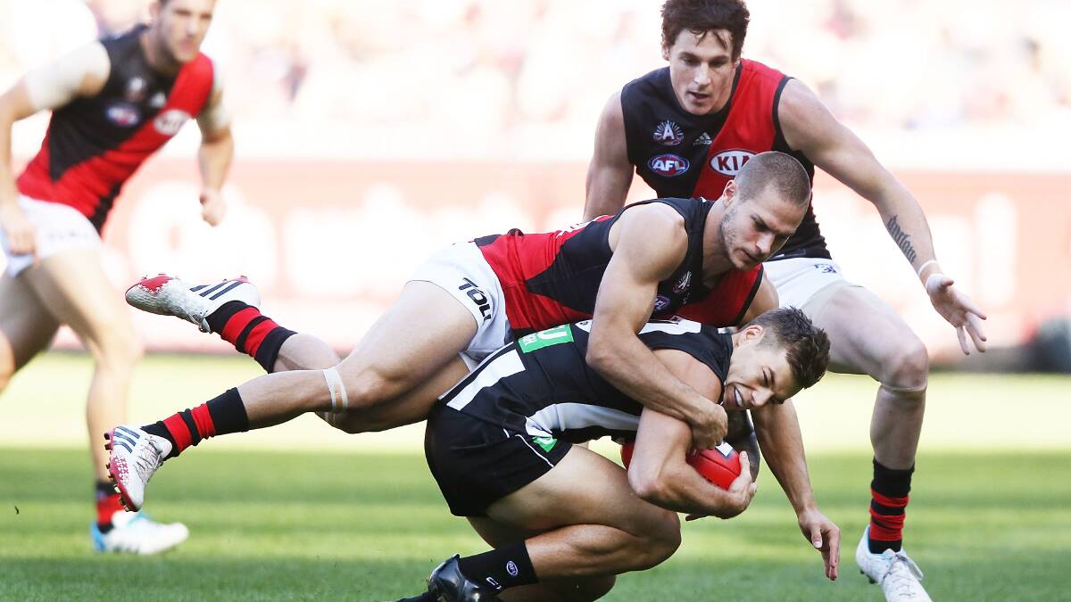 Jamie Elliott of the Magpies is tackled by David Zaharakis of the Bombers. Photo: Getty Images.