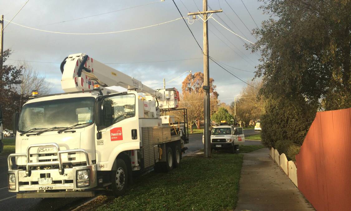 Powercor workers fix up power lines after a car crashed into a pole on La Trobe St in Redan. PHOTO: Alex Hamer