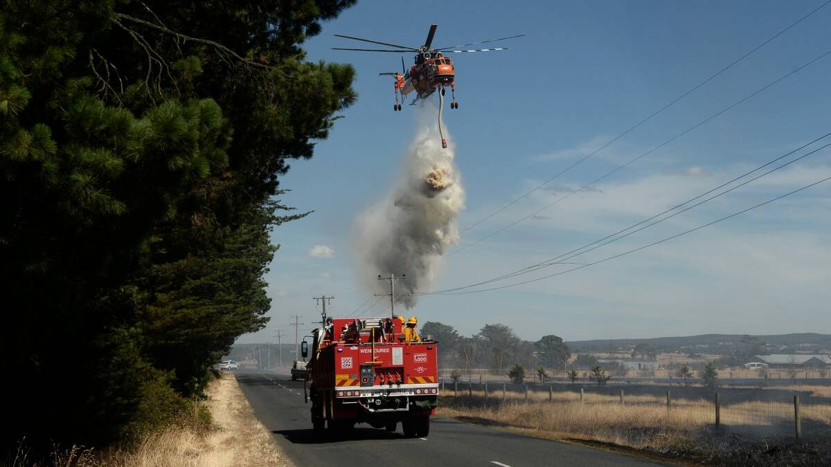 The sky crane Malcolm battles a blaze near Alfredton last Friday. Picture: Adam Trafford