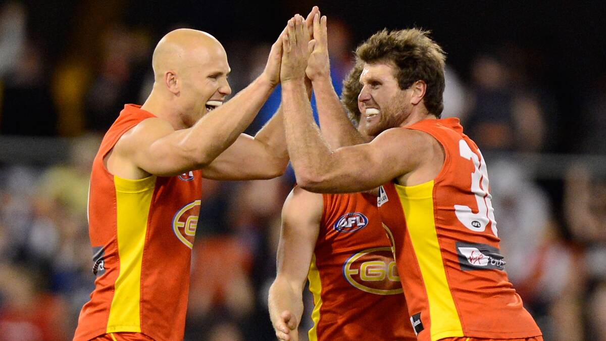 Campbell Brown celebrates with the game's best player, former Geelong champion and Gold Coast captain, Gary Ablett.