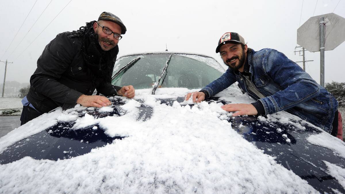 Matt McLean and Ritchard Kendall did their best to keep their car snow-free on the snow day in 2013 at Blampied. PICTURE: JUSTIN WHITELOCK