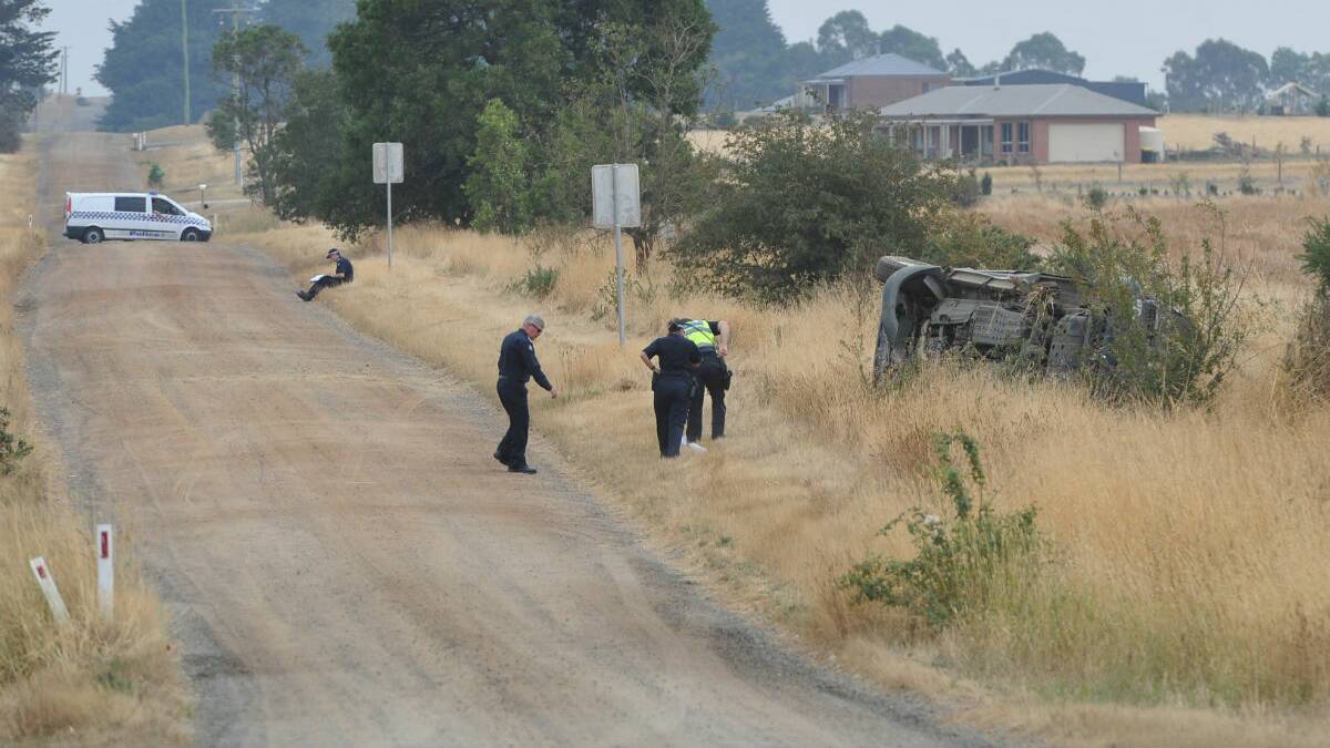 Ballarat Police Inspector Bruce Thomas, left, assesses the crash with crime scene investigators. PICTURE: LACHLAN BENCE