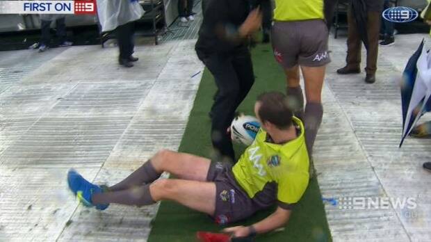 Linesman Nick Beashel hit the deck attempting to avoid a flying bottle. Photo: Channel Nine news