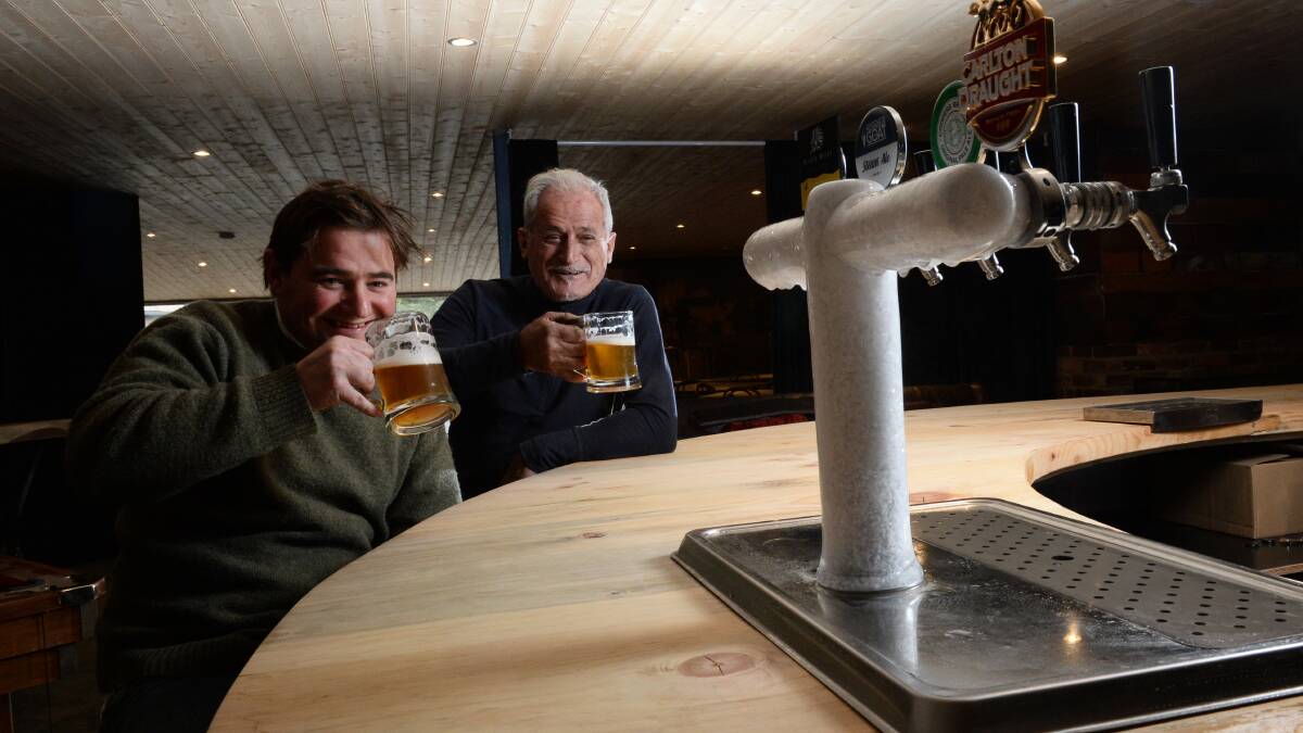 Ewan Apedaile and Jim Frangos enjoy a beer while waiting for the opening of the Swiss Mountain Hotel and Store. PICTURE: ADAM TRAFFORD