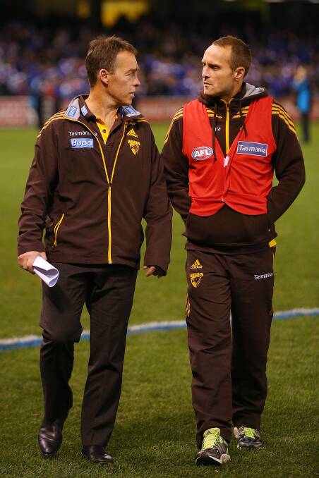 An injured Brad Sewell chats with Hawthorn coach Alastair Clarkson after the Hawks’ loss to North Melbourne. PICTURE: Getty Images