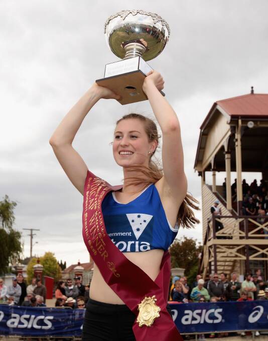 Holly Dobbyn holds aloft her trophy after winning the Stawell Women's Gift.
