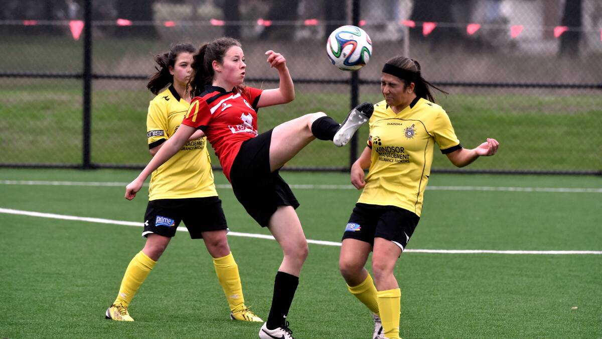  Eyriel McGookin gets a kick away between opponents at Ballarat’s BDSA under-16 girls match against Heidleberg United. PICTURE: JEREMY BANNISTER