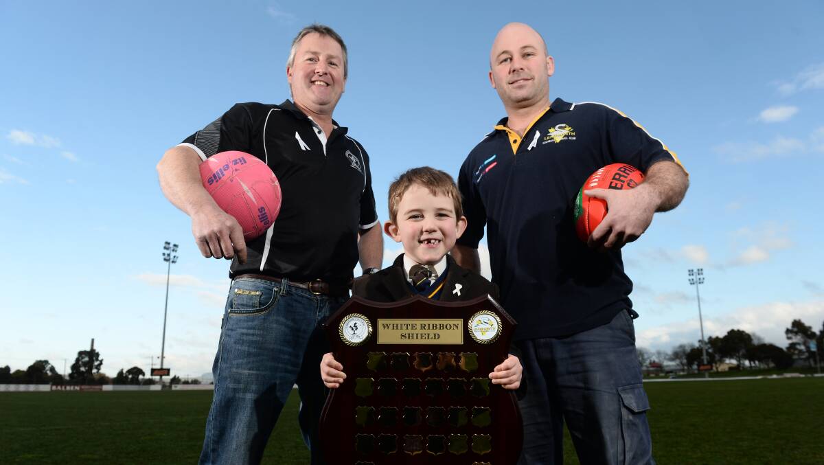  Clunes Football Netball Club president John Bedwell and Learmonth Football Netball Club president Matt Hines with Sharon Siermans’ son Aron, who will present the shield to the winner on Saturday. PICTURE: ADAM TRAFFORD