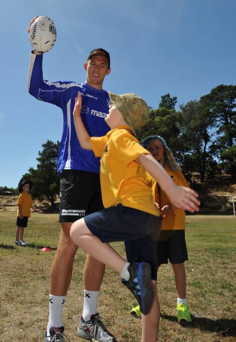 Drew Petrie with Jai Erwin, 7, and Lucy Walters, 9, at North Melbourne’s Ballarat community camp in 2013.