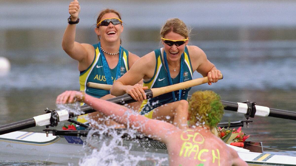 Luke Taylor swims out to congratulate sister Rachael Taylor and Kate Slatter of Australia after they won silver at the Sydney Olympics. Picture: Nick Wilson /Allsport