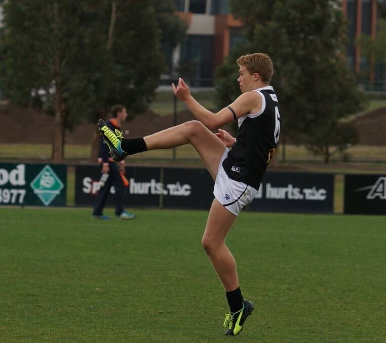 North Ballarat Rebel Shannon Beks kicks cleanly to send his team into attack. Photo: Adam Cornell