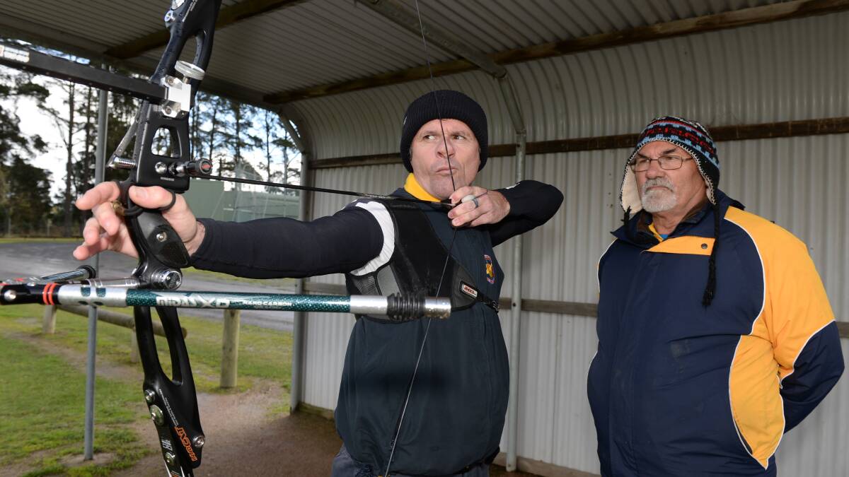 Wendouree Archery Club's Neil Nickless takes aim under the watchful eye of club president John Blake. Photo: Kate Healy