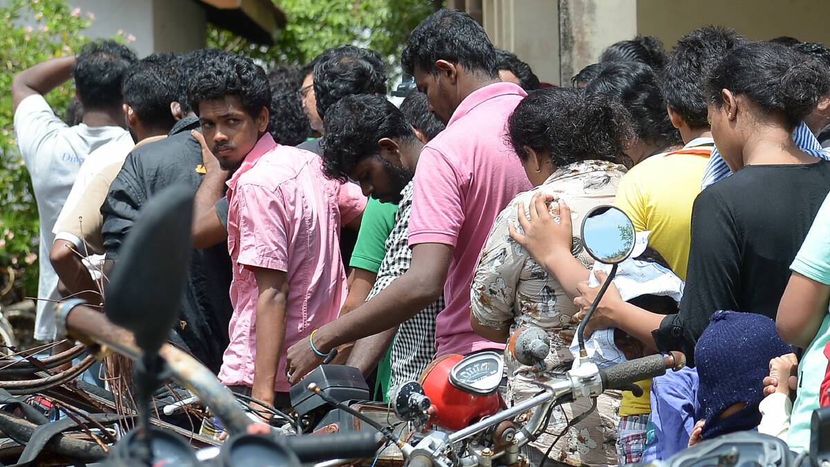 Sri Lankan asylum seekers sent back by Australia queue to enter the magistrate's court in the southern port district of Galle