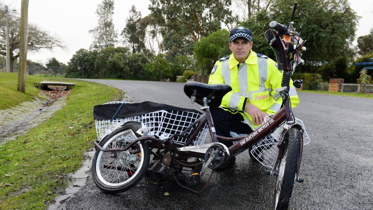 Highway Patrol Senior Constable Craig Walker with Tony Tung's damaged scooter PICTURE: Kate Healy
