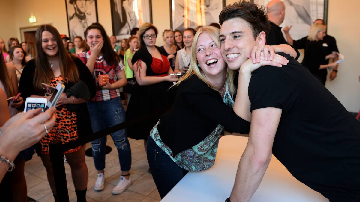 Excited fans wait to meet pop star Taylor Henderson at the Regent Cinemas on Friday night before his sold-out concert, while one fan, Shae Veenstra of Colac, has a photo taken with him. 