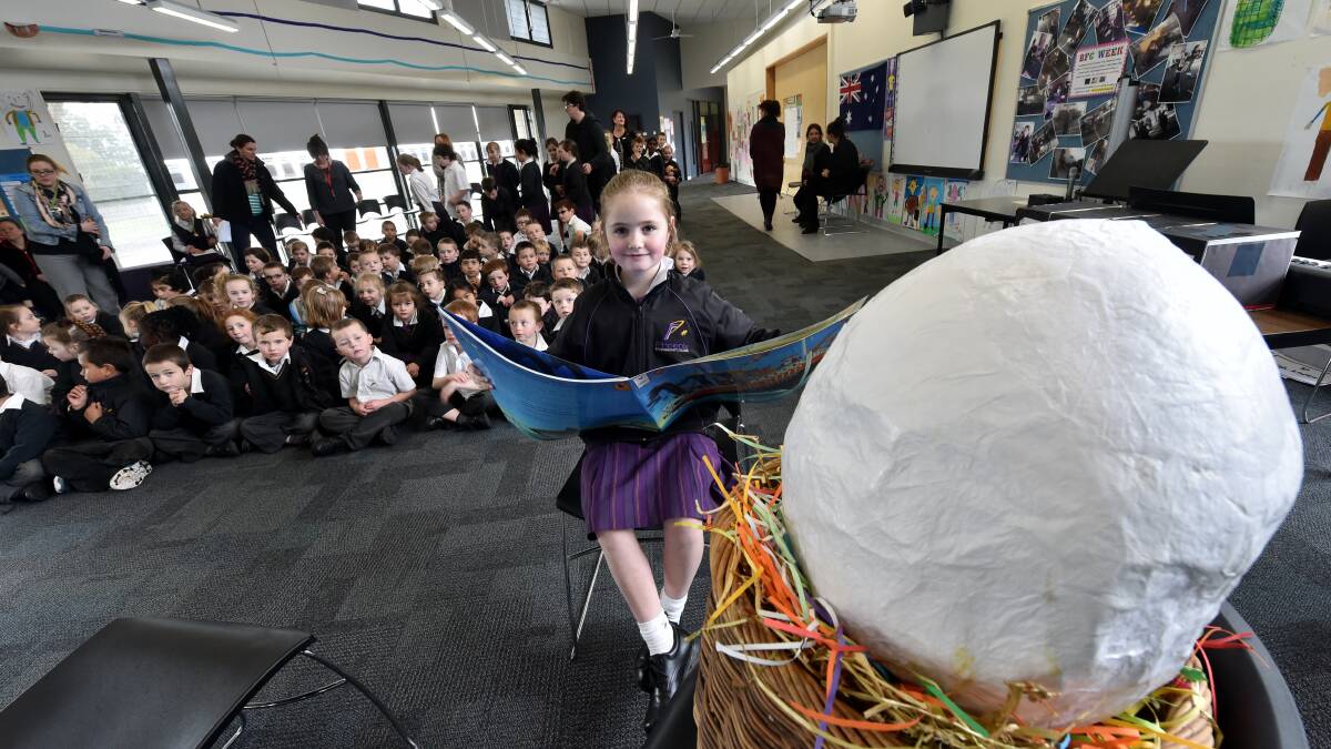Phoenix P-12 Community College grade 1 pupil Isabella Coe takes her turn reading to the egg, which has been at the school for the past few months, before it started moving and a Reading Bug emerged, looking a bit like Jenny Sheriff, and read to the excited children.