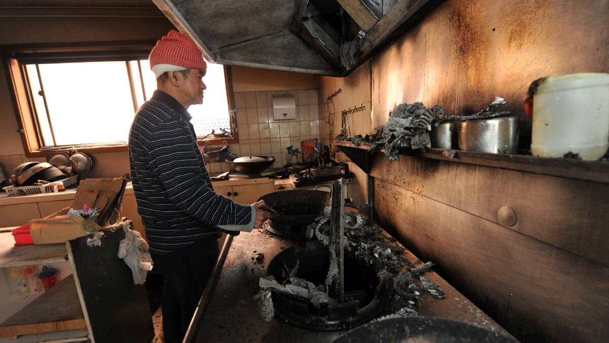 Ian Poon inspects the damage to his shop’s kitchen after the fire yesterday. PICTURE: JEREMY BANNISTER