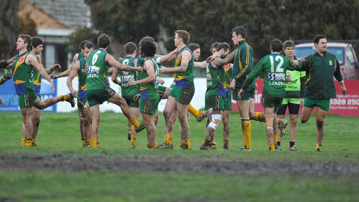Lake Wendouree players stretch on the muddy Wendouree Reserve oval. 