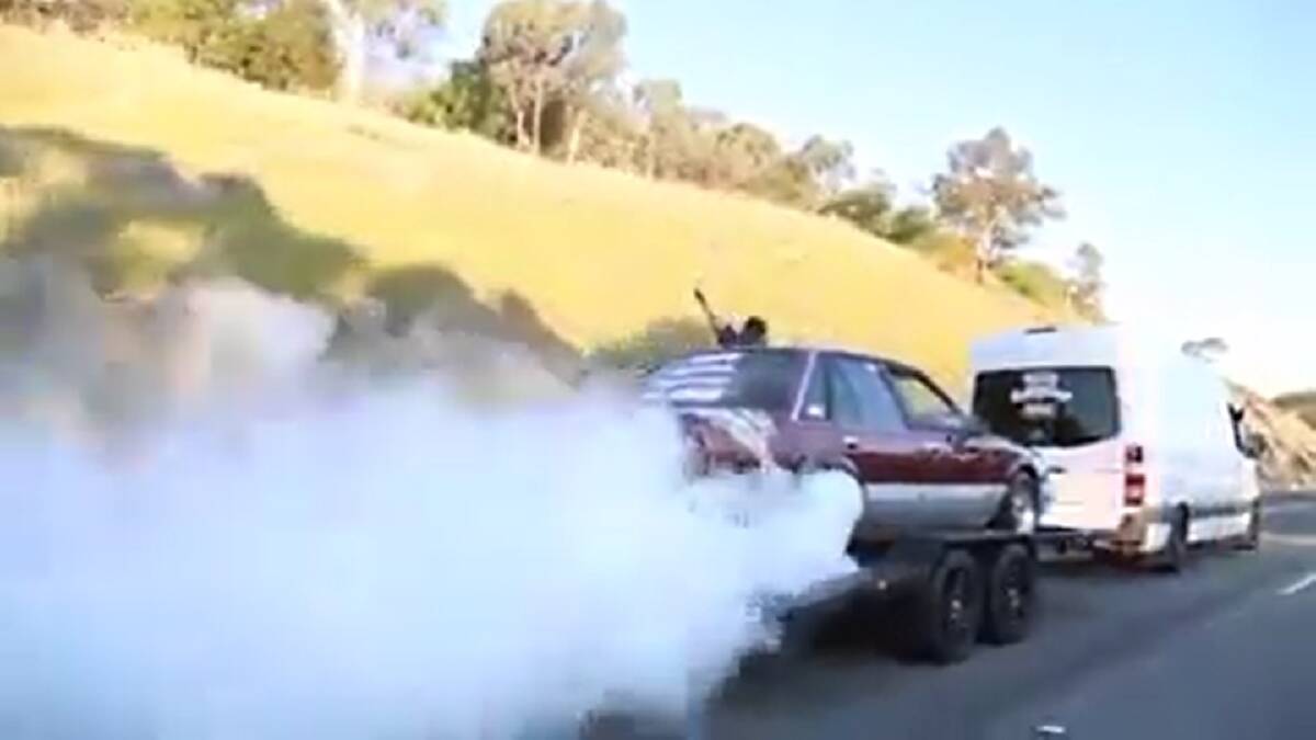 DANGEROUS: A still image from the footage posted on Facebook. The maroon Holden VK Commodore and white van both have sign writing on the rear. 