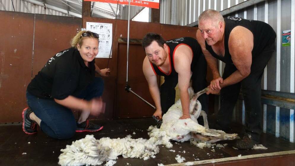 Ben Keenan (centre) enjoying shearing with wool handler Amanda Davis and shearing trainer Kevin Gellatly. Photo: Supplied