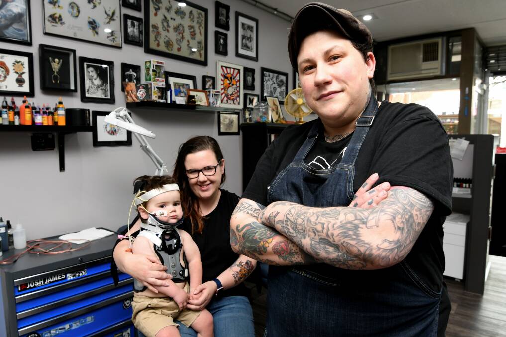 INKED: Baxter Ericksen,2, Emma Fortescue, and tatto artist Randi Canik will be working to help people at the Royal Children's Hospital. Picture: Lachlan Bence.  